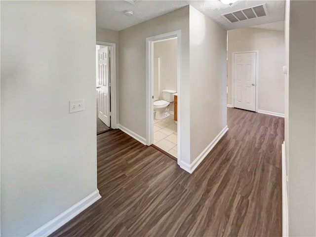 corridor featuring dark wood-type flooring and a textured ceiling