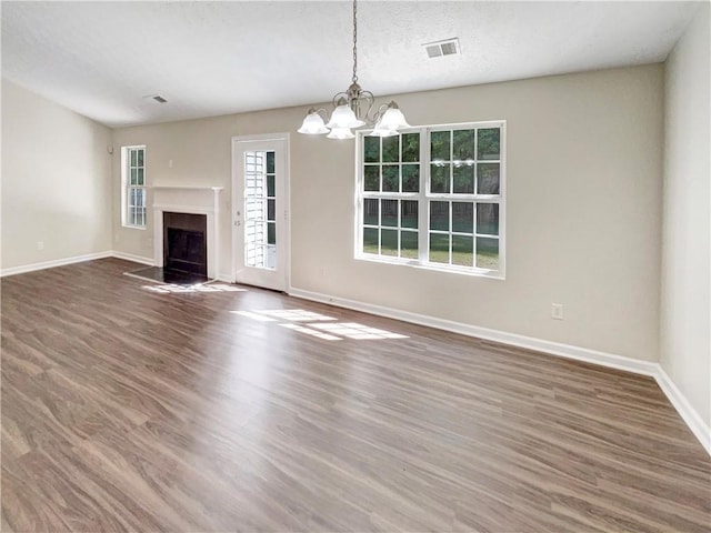 unfurnished living room featuring dark wood-type flooring and a chandelier