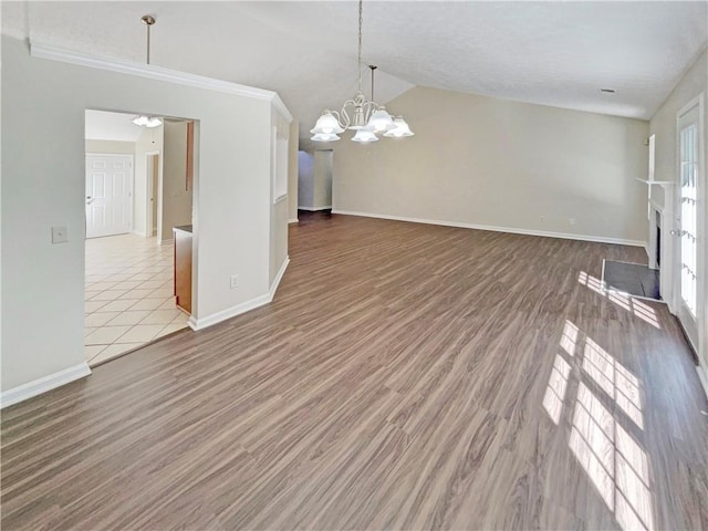 interior space featuring wood-type flooring, vaulted ceiling, and a notable chandelier