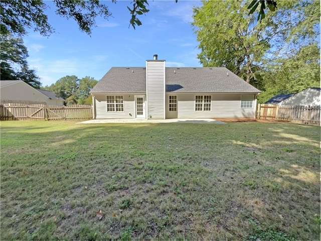 rear view of house featuring a lawn and a patio