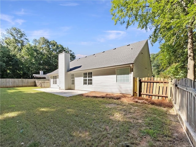 back of property with a yard and a patio