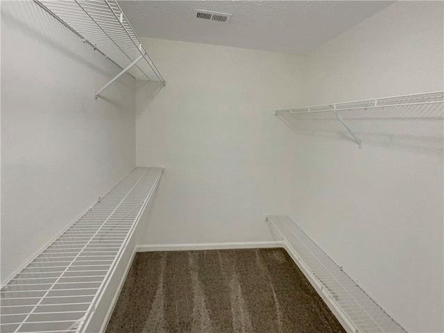 spacious closet with dark carpet