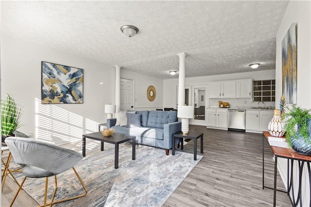 4781 Brownsville Rd, Powder Springs, GA 30127 - living room featuring ornate columns, a textured ceiling, and wood finished floors