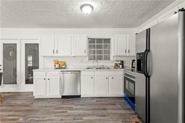 4781 Brownsville Rd, Powder Springs, GA 30127 - kitchen featuring stainless steel appliances, white cabinetry, a sink, a textured ceiling, and dark wood-style flooring