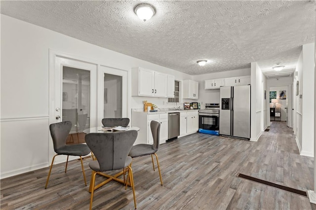 4781 Brownsville Rd, Powder Springs, GA 30127 - dining space featuring light wood-style flooring, a textured ceiling, and baseboards