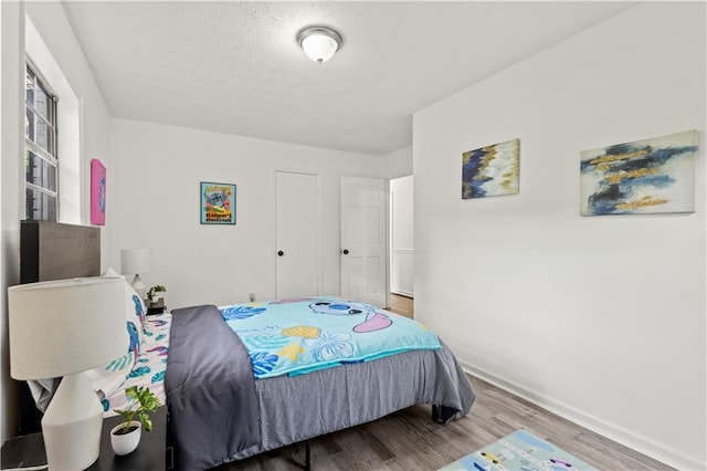 4781 Brownsville Rd, Powder Springs, GA 30127 - bedroom featuring wood finished floors, baseboards, and a textured ceiling