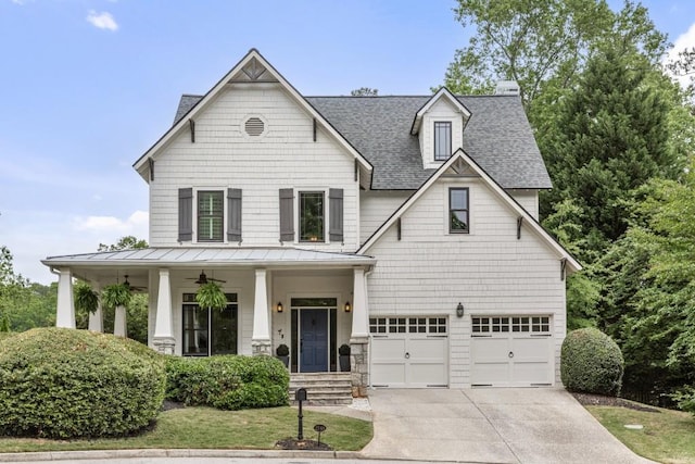 view of front of property featuring an attached garage, a standing seam roof, a shingled roof, concrete driveway, and a porch