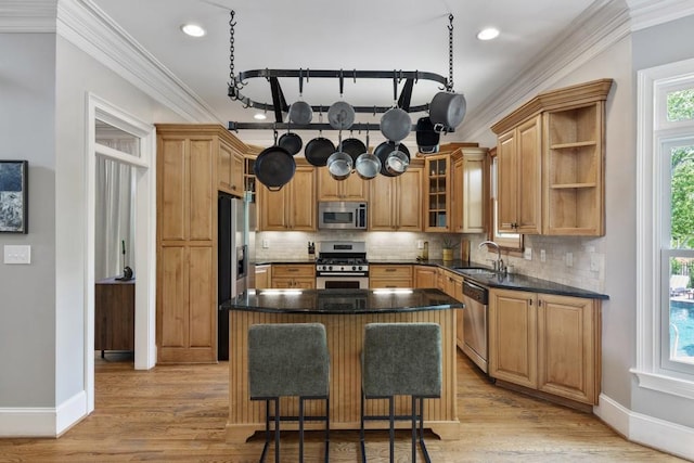 kitchen featuring crown molding, a sink, stainless steel appliances, baseboards, and backsplash