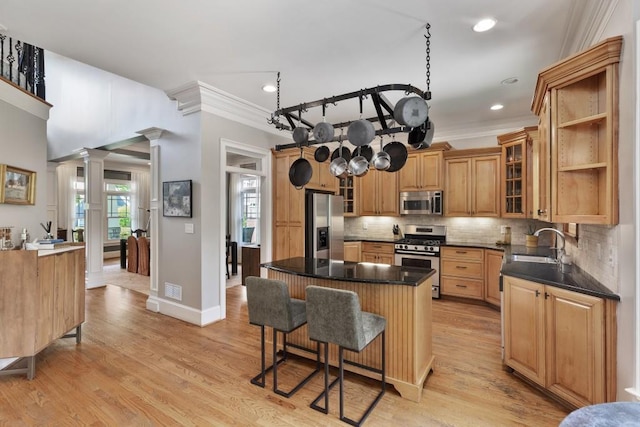 kitchen with decorative backsplash, a breakfast bar area, crown molding, a center island, and stainless steel appliances
