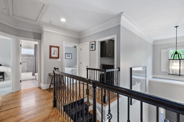 hallway with attic access, baseboards, light wood finished floors, an upstairs landing, and recessed lighting
