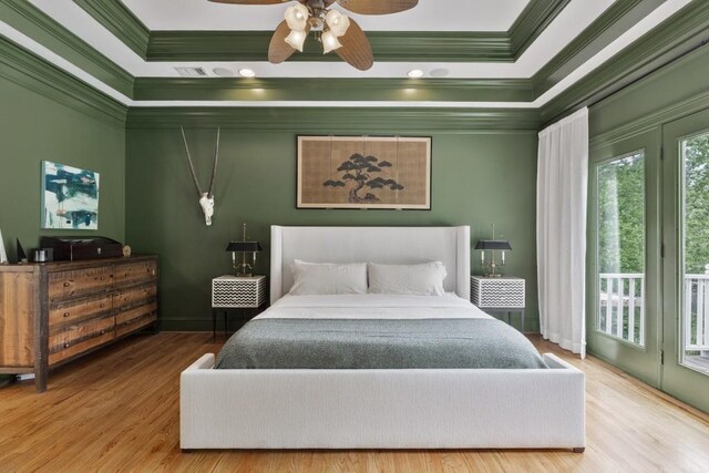 bedroom with crown molding, baseboards, wood finished floors, and access to exterior