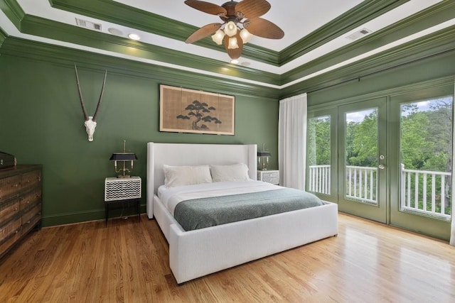 bedroom with access to outside, ceiling fan, wood finished floors, visible vents, and ornamental molding