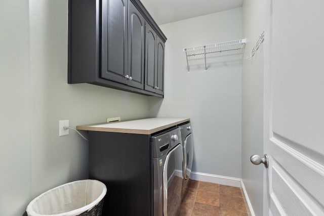 clothes washing area featuring cabinet space, baseboards, and washing machine and dryer