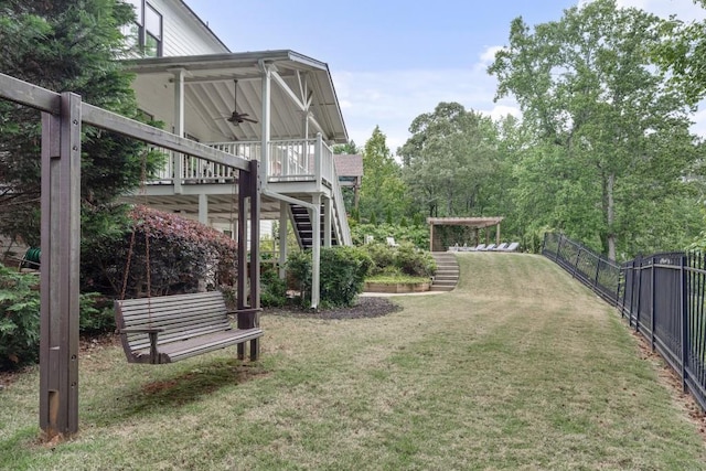 view of yard featuring fence, stairs, ceiling fan, and a wooden deck