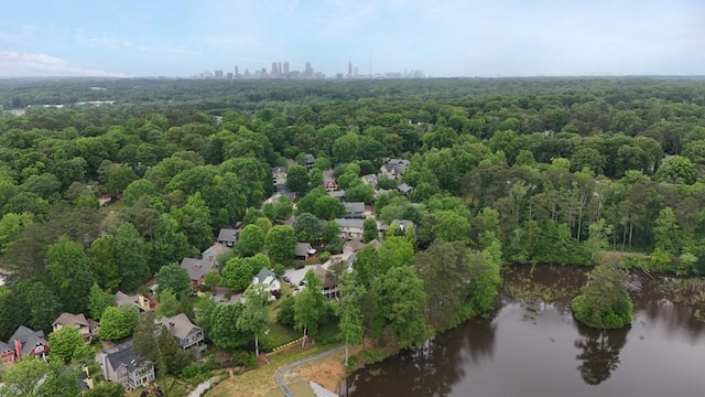 bird's eye view with a water view and a wooded view