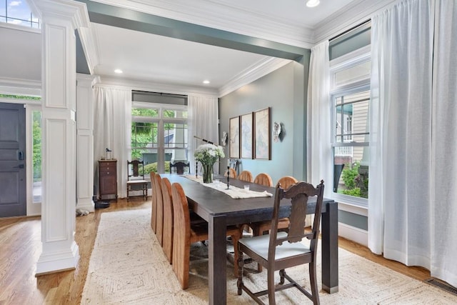 dining space featuring crown molding, ornate columns, recessed lighting, and light wood-style floors
