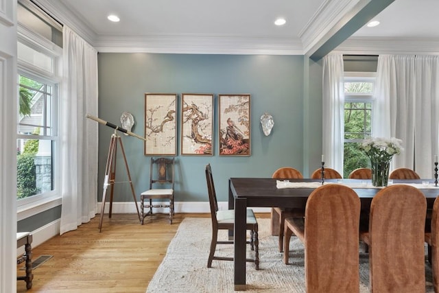 dining area with baseboards, crown molding, and wood finished floors