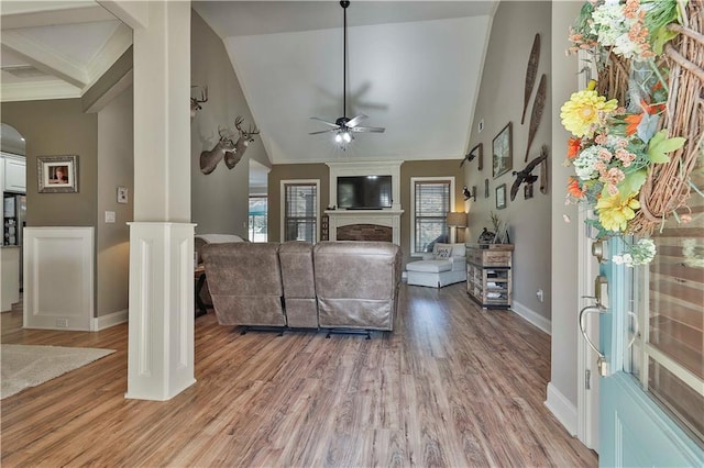 living room featuring ornate columns, ceiling fan, high vaulted ceiling, and wood-type flooring