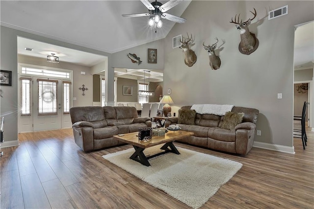 living room featuring hardwood / wood-style floors, ceiling fan, lofted ceiling, and ornamental molding