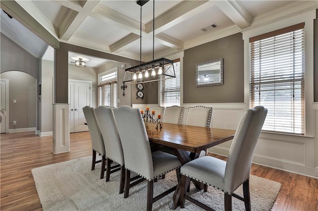 dining room with beam ceiling, hardwood / wood-style flooring, ornamental molding, and coffered ceiling