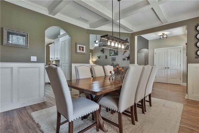 dining space featuring beamed ceiling, hardwood / wood-style flooring, ceiling fan, and coffered ceiling