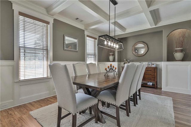 dining room with hardwood / wood-style floors, beam ceiling, crown molding, and coffered ceiling