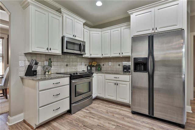 kitchen featuring white cabinets, light wood-type flooring, stainless steel appliances, and ornamental molding