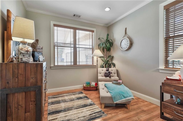 sitting room with light wood-type flooring and ornamental molding