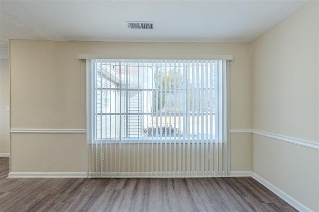 unfurnished room featuring a wealth of natural light and dark hardwood / wood-style flooring