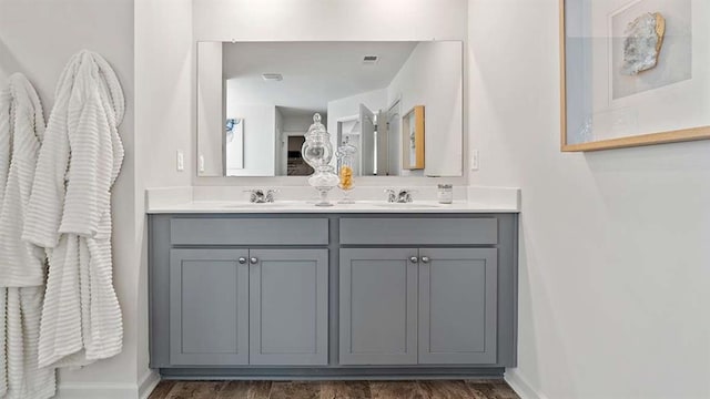 full bathroom with a sink, visible vents, baseboards, and double vanity