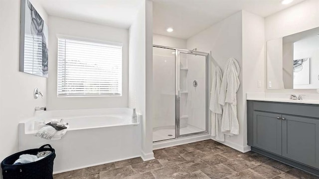 bathroom featuring baseboards, a stall shower, vanity, and a garden tub