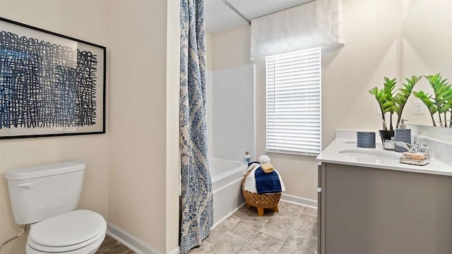 full bath featuring toilet, vanity, baseboards, and shower / bath combo