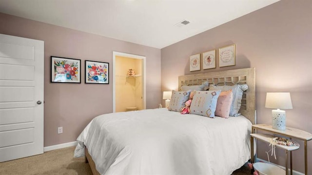 bedroom with visible vents, baseboards, ensuite bathroom, and carpet