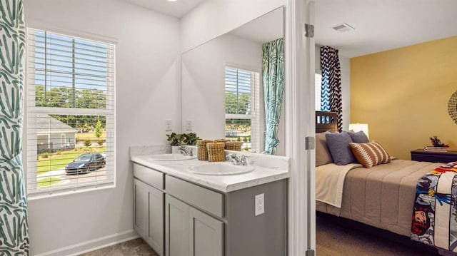 ensuite bathroom featuring a sink, connected bathroom, visible vents, and double vanity