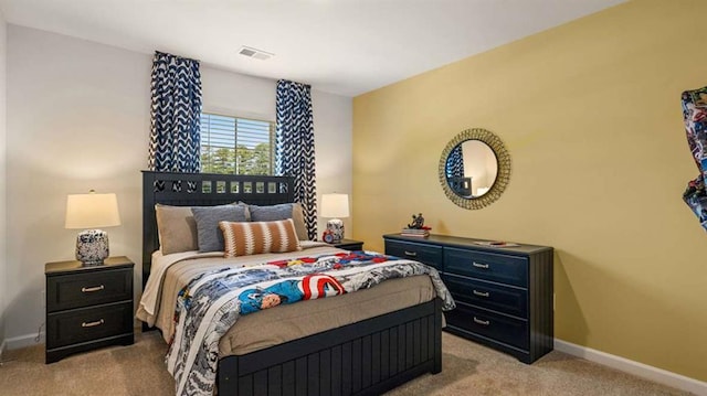 bedroom with visible vents, baseboards, and light carpet