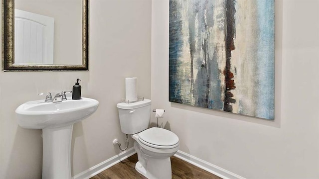 bathroom featuring baseboards, toilet, and wood finished floors