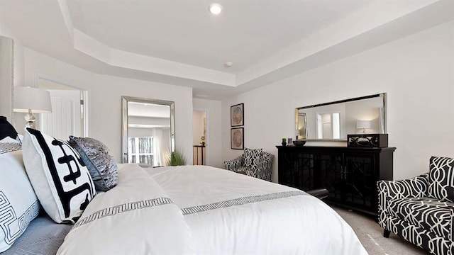 bedroom featuring a raised ceiling and carpet floors