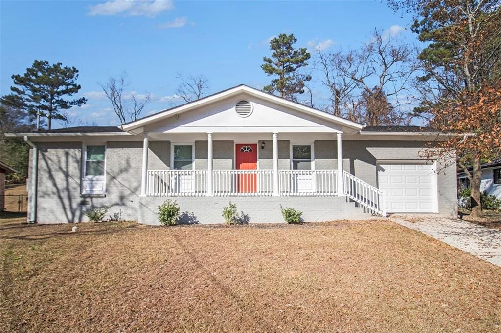 ranch-style home featuring covered porch and a garage