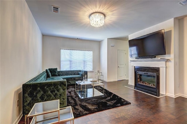 1005 Belfry Ter, Fairburn, GA 30213 - living room featuring a chandelier, wood finished floors, a glass covered fireplace, and baseboards