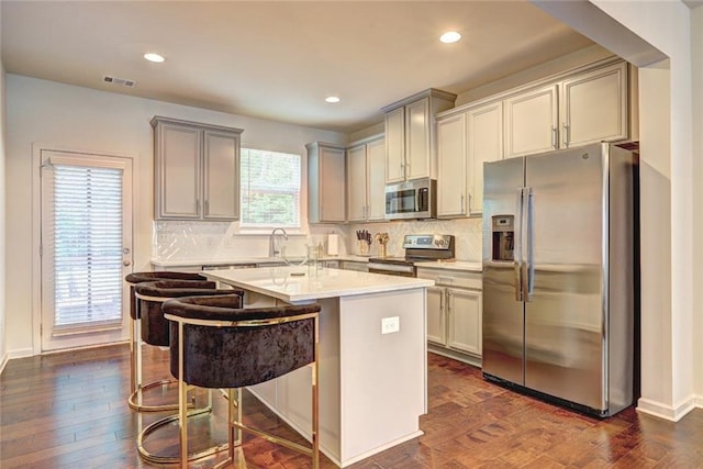 1005 Belfry Ter, Fairburn, GA 30213 - kitchen featuring appliances with stainless steel finishes, dark wood-style flooring, a center island, gray cabinetry, and recessed lighting