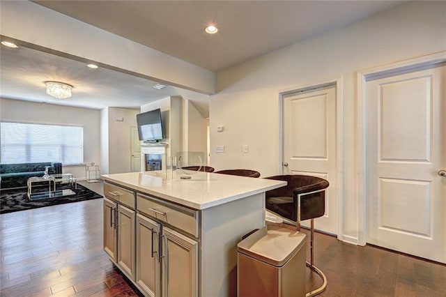 1005 Belfry Ter, Fairburn, GA 30213 - kitchen featuring a breakfast bar, dark wood-type flooring, open floor plan, recessed lighting, and a kitchen island