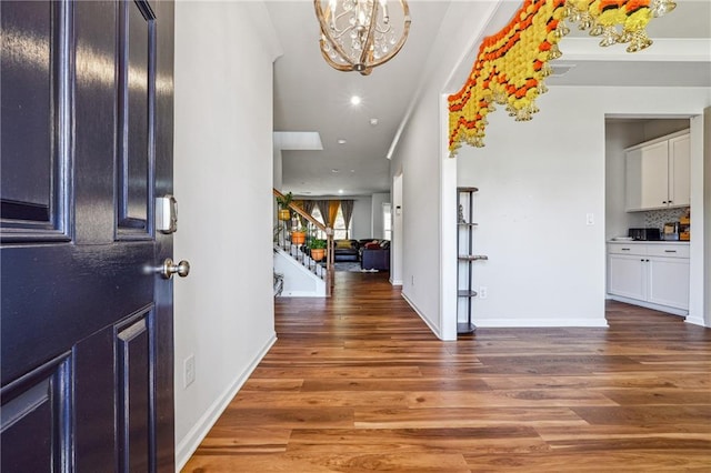 foyer entrance featuring ornamental molding, dark hardwood / wood-style floors, and an inviting chandelier