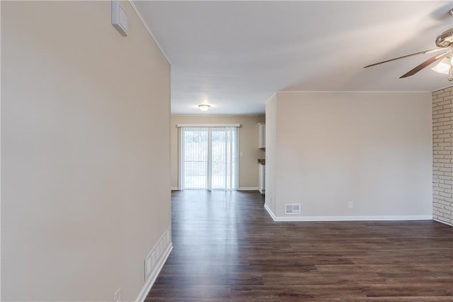 unfurnished room featuring dark wood-style flooring, visible vents, ceiling fan, and baseboards