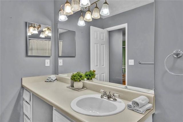 bathroom with a notable chandelier and vanity