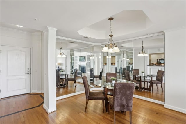 dining area featuring ornamental molding, baseboards, visible vents, and wood finished floors