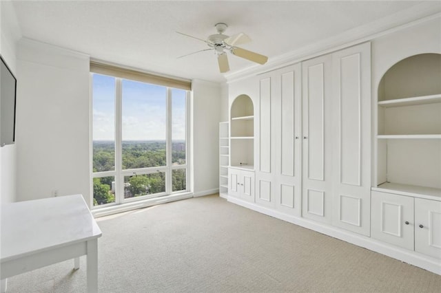 interior space featuring carpet, a ceiling fan, and ornamental molding