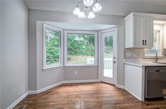 17 Fawn Ridge Dr SW, Cartersville, GA 30120 - kitchen with stainless steel dishwasher, wood finished floors, white cabinets, light countertops, and a chandelier