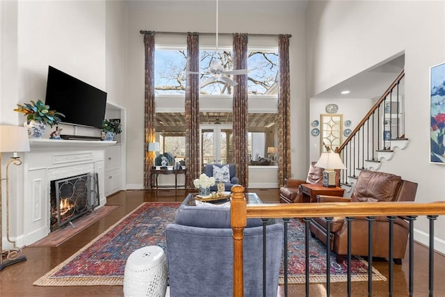 1374 Riverside Dr, Gainesville, GA 30501 - living room with a towering ceiling, a lit fireplace, wood finished floors, stairs, and baseboards