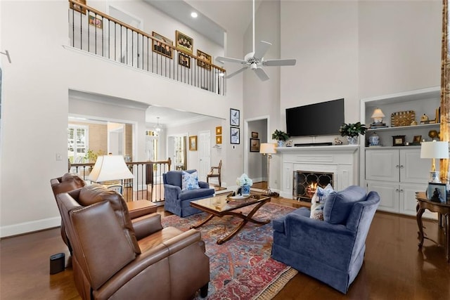 1374 Riverside Dr, Gainesville, GA 30501 - living room with a high ceiling, ceiling fan, a warm lit fireplace, baseboards, and wood finished floors