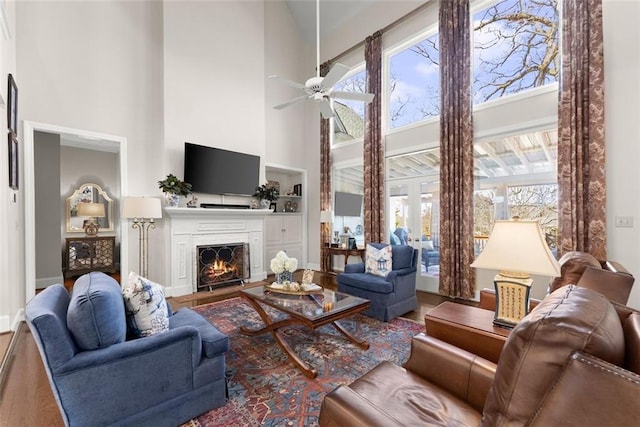 1374 Riverside Dr, Gainesville, GA 30501 - living area featuring a lit fireplace, a ceiling fan, a high ceiling, wood finished floors, and baseboards